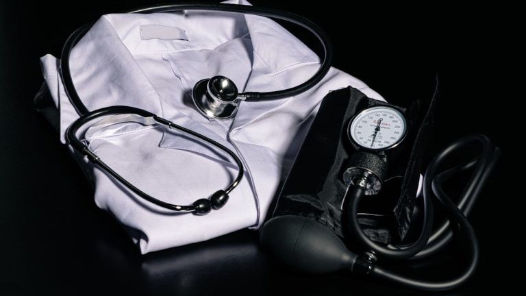 black and silver stethoscope on white textile