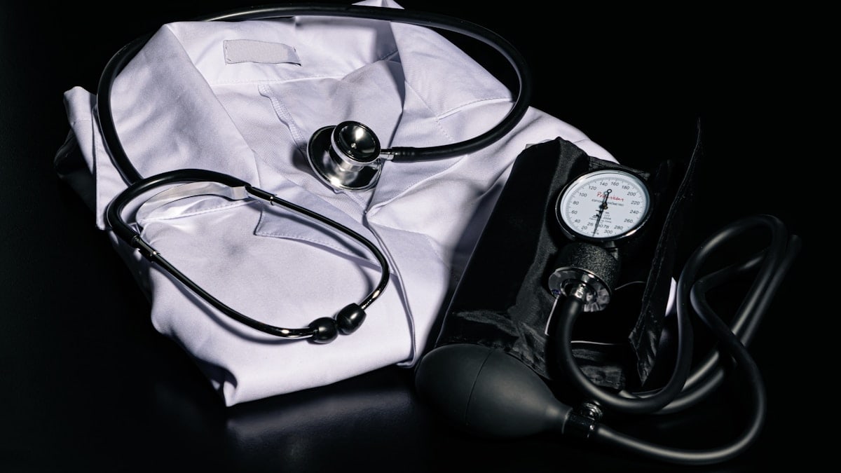 black and silver stethoscope on white textile